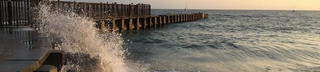 Waves crash against a jetty in Playa Del Rey, California, at sunset.